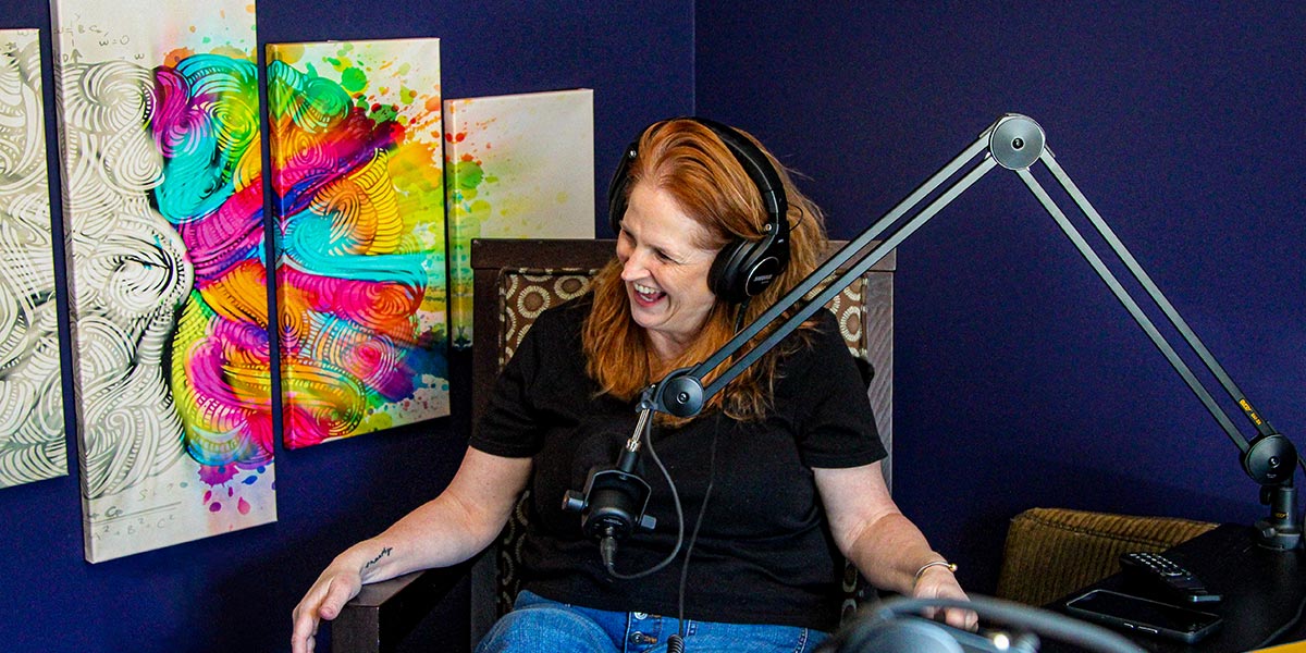 Joanne Secky, Natural Born Red Head, laughing in front of a mic.
